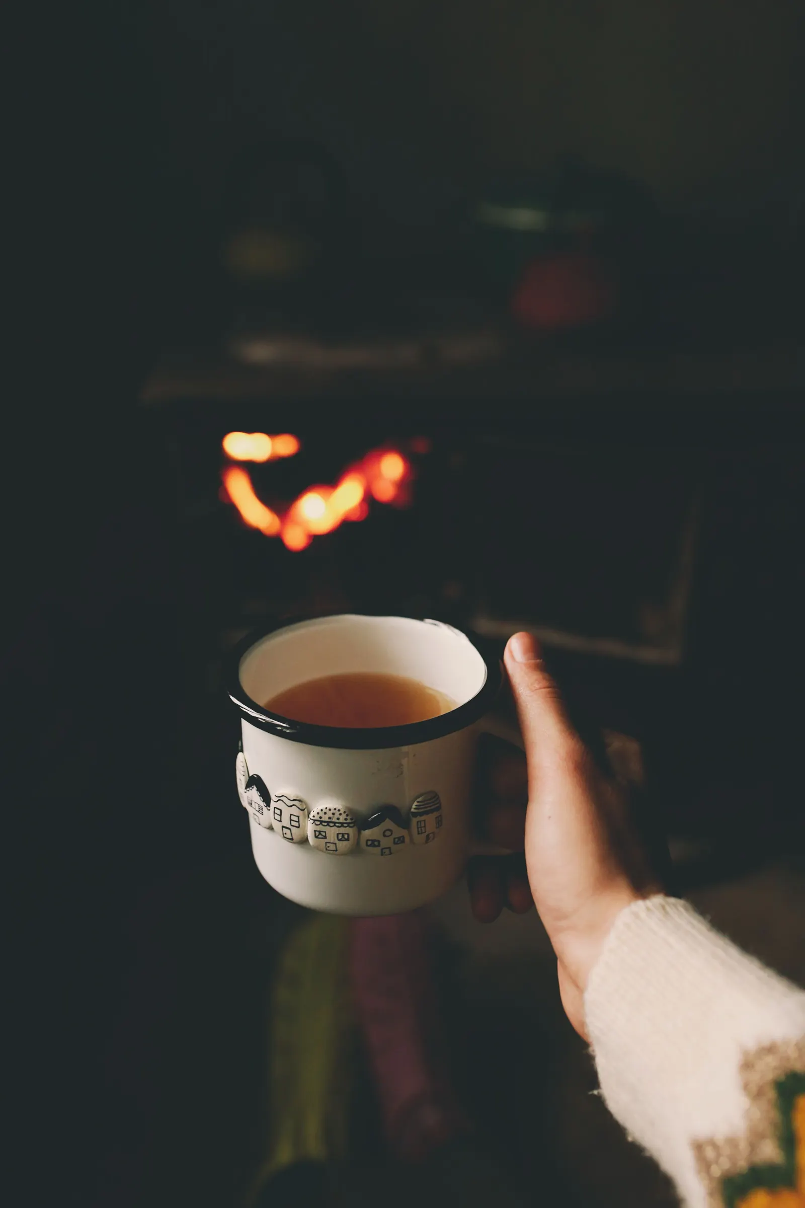 Deux mains entourant une tasse de thé chaude